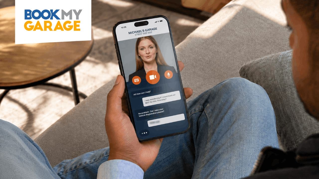 Man sat on sofa looking at phone screen interacting with new BookMyGarage AI assistant